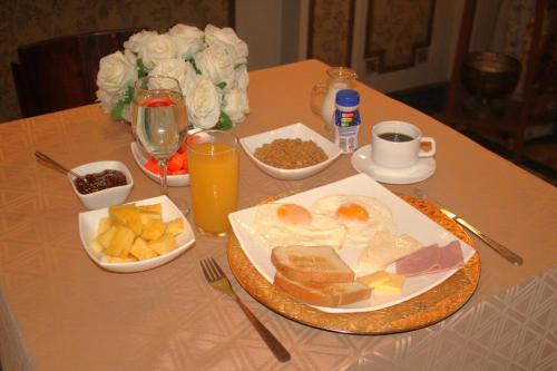 a table with a plate of breakfast food and drinks at Hotel Boutique Mansion Del Rio in Guayaquil