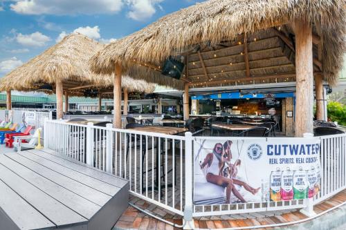a restaurant with a straw umbrella and a table and chairs at Ramada by Wyndham Sarasota Waterfront in Sarasota