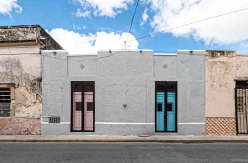 a white building with colorful doors on a street at Casona de las Mestizas in Mérida