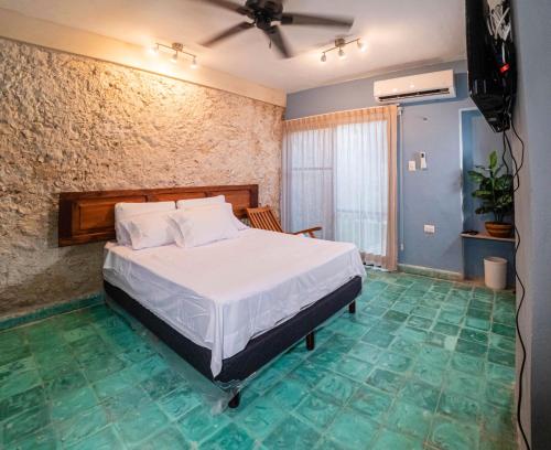 1 dormitorio con 1 cama en una habitación con suelo verde en Casona de las Mestizas en Mérida