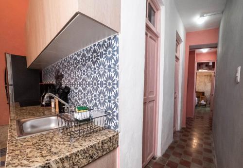 cocina con fregadero y pared de azulejos en Casona de las Mestizas en Mérida