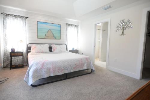 a white bedroom with a bed and a chandelier at Waterfront Retreat, Heated Pool, Fishing in Port Charlotte