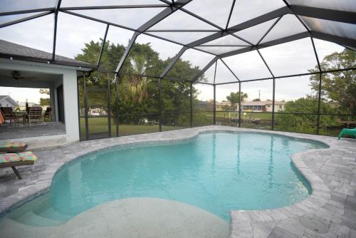 a large swimming pool with a glass roof at Waterfront Retreat, Heated Pool, Fishing in Port Charlotte