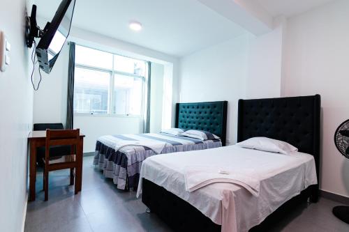 - une chambre avec 2 lits, un bureau et une fenêtre dans l'établissement Hotel Casa Nova jaen, à Jaén