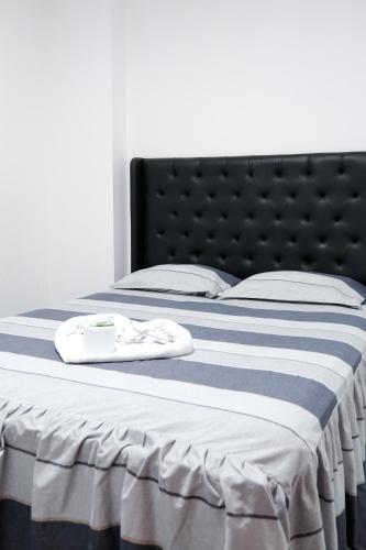 a bed with a blue and white striped blanket at Hotel Casa Nova jaen in Jaén
