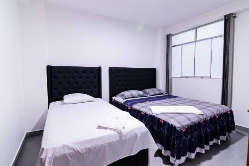- deux lits assis l'un à côté de l'autre dans une pièce dans l'établissement Hotel Casa Nova jaen, à Jaén