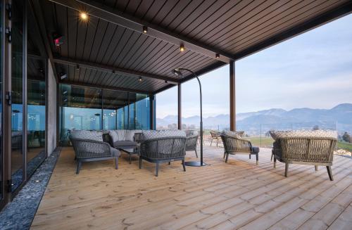 a deck with chairs and tables on top of a building at Collina Luxury Relais in Clusone