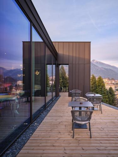 a building with a deck with tables and windows at Collina Luxury Relais in Clusone