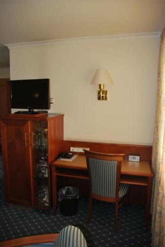 a hotel room with a desk and a television at Hotel-Gasthof Maisberger in Neufahrn bei Freising