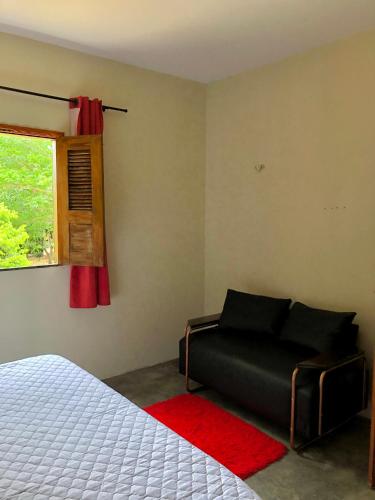 een slaapkamer met een bed en een raam bij Sítio Primavera in Ipueiras