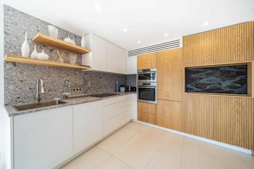 une cuisine avec des armoires blanches et un évier dans l'établissement Sublime 3 bedroom with roof terrace, à Cannes