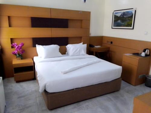 a bedroom with a large bed with white sheets at Desikok Royal Hotel LTD in Port Harcourt