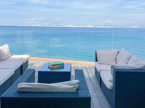 Un balcón con sillas y vista al mar. en Villa vue mer panoramique - sauna - balnéothérapie, en Marsella