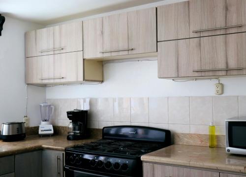 une cuisine avec des armoires en bois et un four à plaques de cuisson dans l'établissement Benavente, Casa hogareña para familias grandes, à Tehuacán