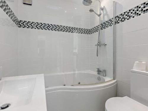 a white bathroom with a tub and a toilet at 2 Bed in Brixham 90912 in Brixham