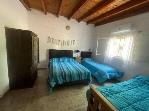 a bedroom with two beds and a dresser at Departamento El Virula in Villa Unión