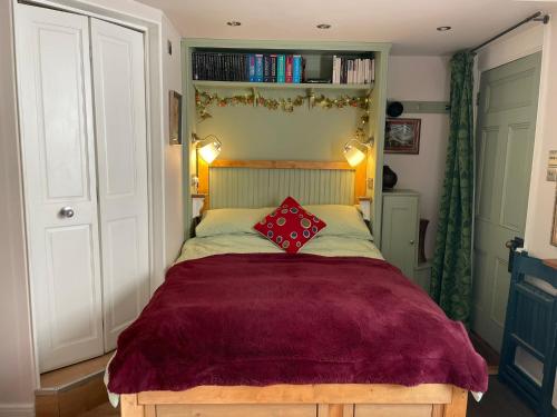 - une chambre avec un grand lit et un oreiller rouge dans l'établissement Little House Felixstowe, à Felixstowe