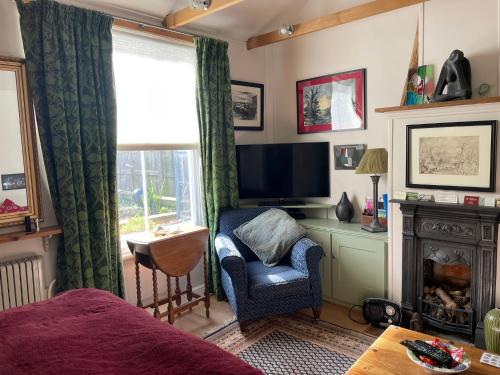 a bedroom with a bed and a chair and a television at Little House Felixstowe in Felixstowe