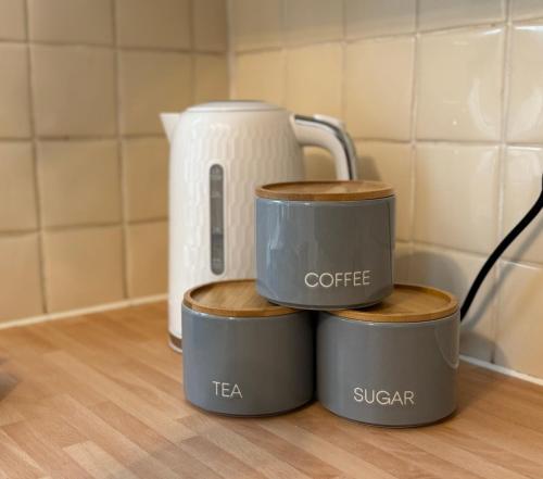 four mugs stacked on top of each other on a counter at Cosy home with parking close to city centre in Exeter