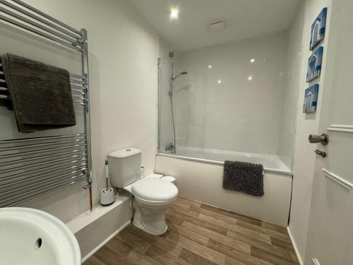 y baño con aseo, bañera y lavamanos. en Cosy home with parking close to city centre, en Exeter