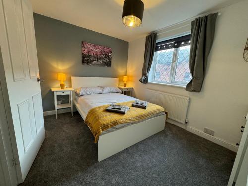 a bedroom with a bed and two lamps and a window at Cosy home with parking close to city centre in Exeter