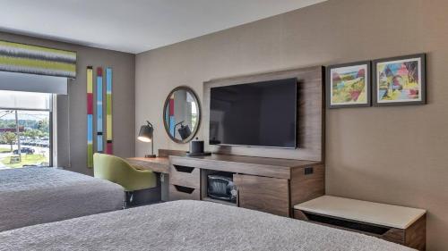 a hotel room with two beds and a television at Hampton Inn & Suites Keene in Keene