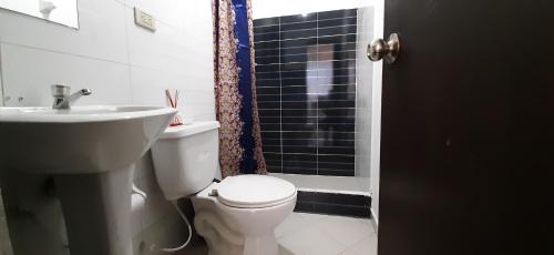 y baño con aseo, lavabo y ducha. en Apartamentos Turisticos EL ZIPA, en Zipaquirá