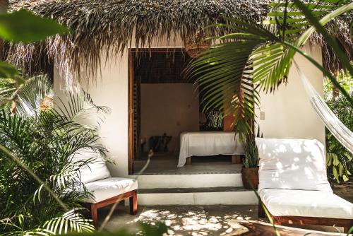 a room with a bed and a table and chairs at Casa Chula Hotel Boutique Frente al Mar in Tierra Blanca