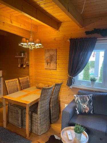 salon ze stołem i kanapą w obiekcie Drewniany domek nad Miedwiem w mieście Morzyczyn