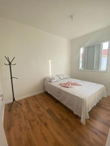 Casa em Condomínio Fechado في بيلوتاس: غرفة نوم مع سرير مع صليب على الحائط