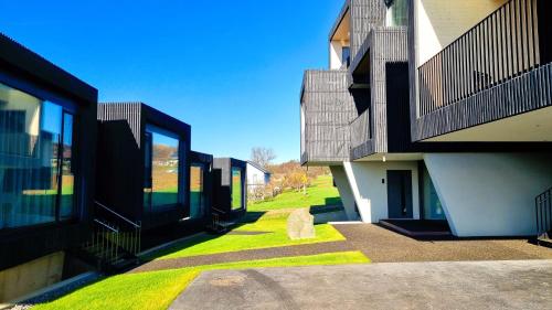 a walkway between two buildings with green grass at Stock & Stein Lodges in Bad Gleichenberg