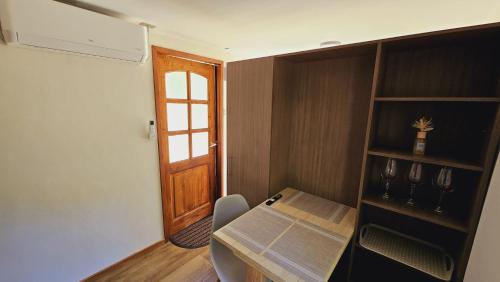 Habitación pequeña con mesa y puerta de madera. en Ketrawe Lodge, en Pucón