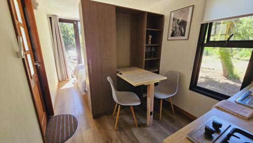 una casa pequeña con mesa y sillas en una habitación en Ketrawe Lodge, en Pucón