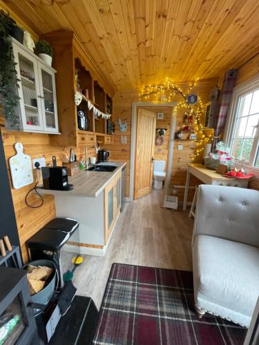 a kitchen with wooden ceilings and a couch in a room at Keepers Shepherd hut with Hot Tub in Whitby