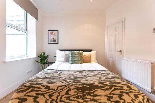 a bedroom with a large bed with a tiger print blanket at Stylish 1-Bed Flat in Liverpool by 53 Degrees Property, Ideal for Business & Long-Term Stays! in Liverpool