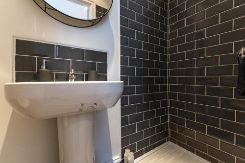 リバプールにあるStylish 1-Bed Flat in Liverpool by 53 Degrees Property, Ideal for Business & Long-Term Stays!の白い洗面台と鏡のあるバスルーム