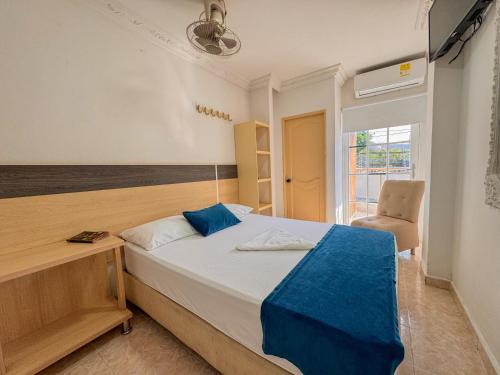 1 dormitorio con cama, escritorio y silla en Hotel Caribe Real Inn en Santa Marta