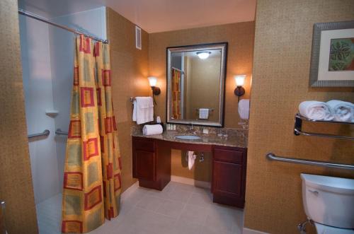 Homewood Suites Medford في ميدفورد: حمام مع حوض ومرحاض ومرآة