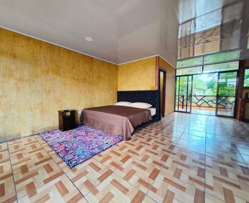 a bedroom with a bed and a wooden floor at BEST PRICE HOUSE in Hot Springs Near La Fortuna in Quesada
