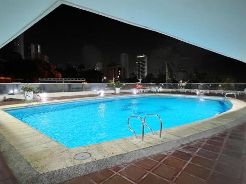 a swimming pool on the roof of a building at night at Acogedor Apartamento Para Grupos Cerca Al Mar Por Parceros Group in Cartagena de Indias