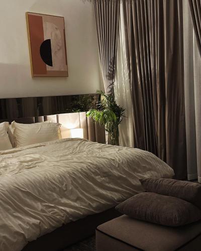 een slaapkamer met een bed en een raam met gordijnen bij شالية سَال الفندقي in Buraydah