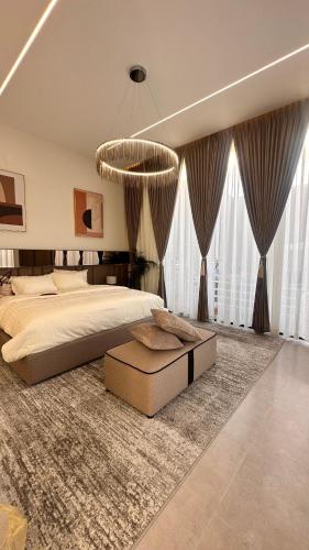 a large bedroom with a large bed and a chandelier at شالية سَال الفندقي in Buraydah