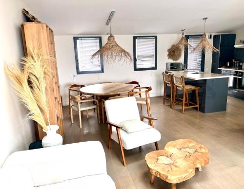 Il comprend un salon avec une table et des chaises ainsi qu'une cuisine. dans l'établissement Villa luxe vue mer panoramique - sauna-hamam - jacuzzi, à Marseille