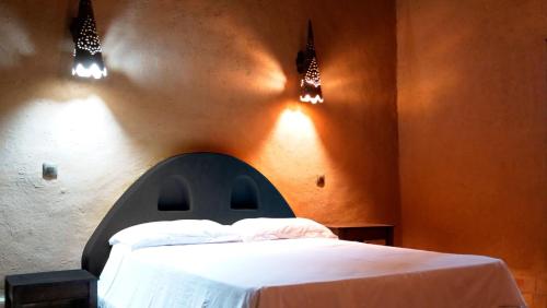 a bedroom with a bed with a blue headboard and lights at JNANE ZOHRA in Taroudant
