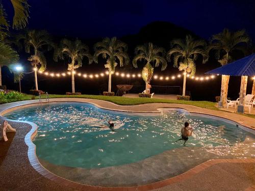 two people swimming in a pool at night at Ecohotel Campo Alegre Norcasia Caldas in Norcasia