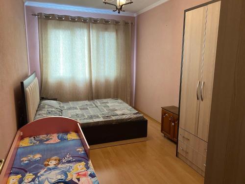 ein kleines Schlafzimmer mit einem Bett und einem Fenster in der Unterkunft Comfortable 2-BR for 5 in Tirana