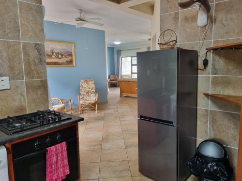 a kitchen with a stove and a refrigerator at Spacious apartment with lovely sea view in Hibberdene