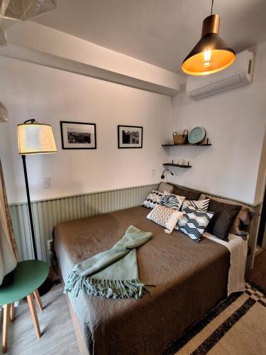 a bedroom with a bed in a room with a lamp at Cafofinho Decor in Sao Paulo