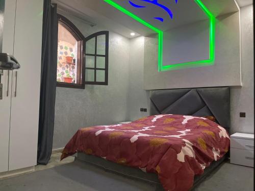 a bedroom with a bed and a green light at Riad Targante Takate 1 in Sidi Bibi