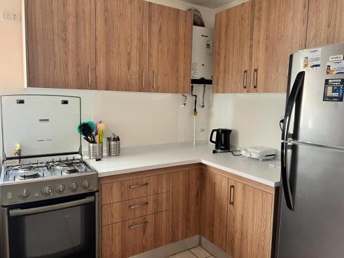 cocina con armarios de madera y nevera de acero inoxidable en Amplia Casa 8 dormitorios 4 baños Avenida Lircay, en Talca